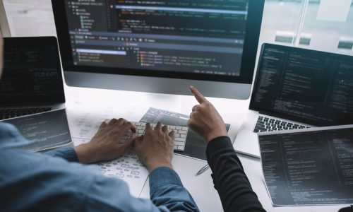 Professional development programmer cooperating meeting programming website working a software in office room.